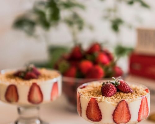 Elegant presentation of homemade strawberry tiramisu with crushed biscuits.